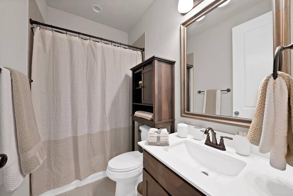 1905 Silver Falls Drive, Burleson, TX 76028 Bathroom featuring a vanity with a white countertop and a dark bronze faucet, a framed mirror, and a toilet
