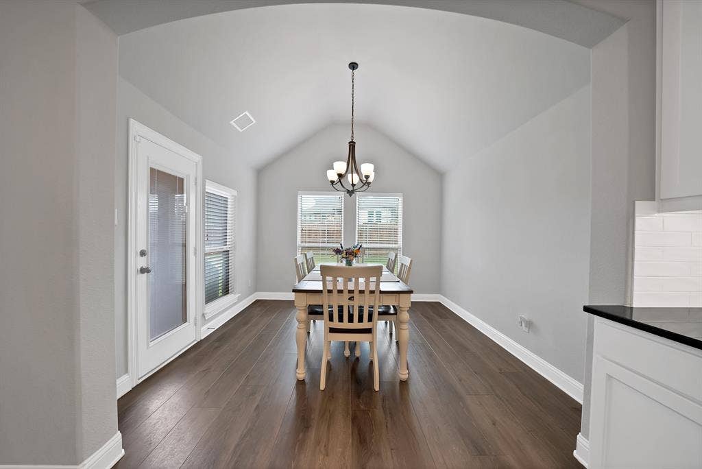 1905 Silver Falls Drive, Burleson, TX 76028 Dining area featuring vaulted ceilings, a contemporary chandelier, and rich wood flooring