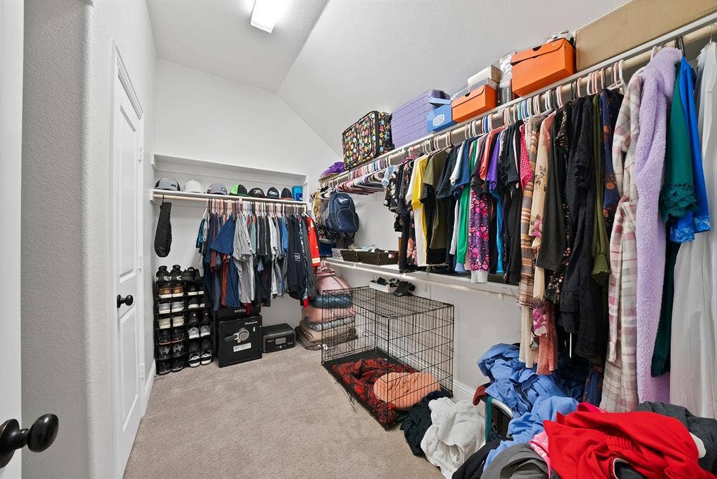 1905 Silver Falls Drive, Burleson, TX 76028 This spacious walk-in closet features extensive hanging rod storage, integrated shelving, and carpeted flooring