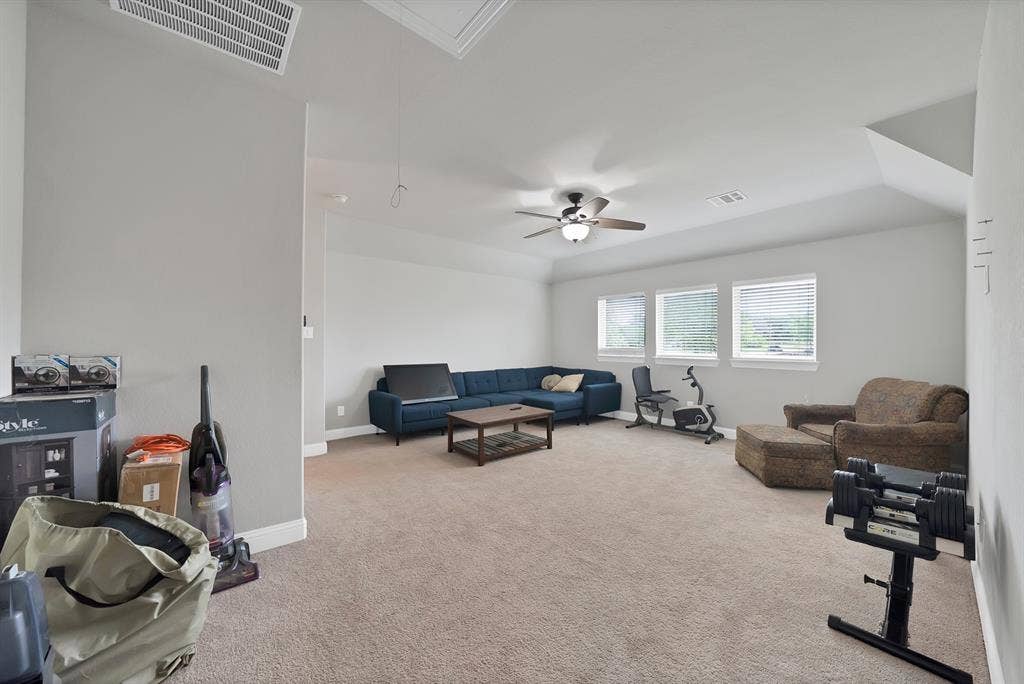 1905 Silver Falls Drive, Burleson, TX 76028 Spacious room featuring carpeted flooring, a ceiling fan with lighting, and multiple windows providing natural light