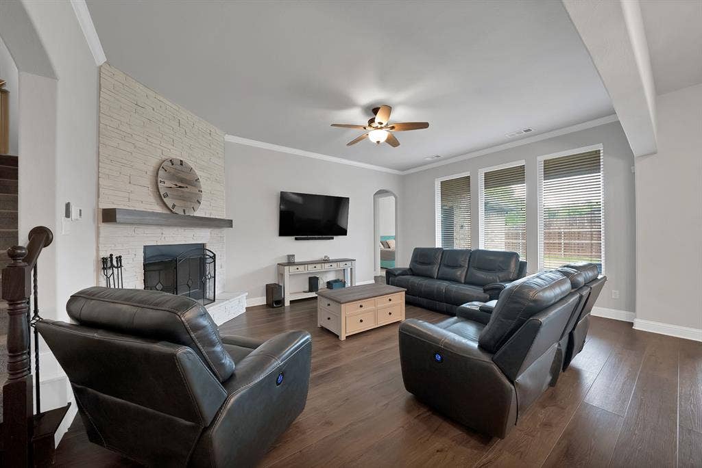 1905 Silver Falls Drive, Burleson, TX 76028 Living area featuring hardwood floors, a white brick fireplace with a mantle, and large windows with blinds
