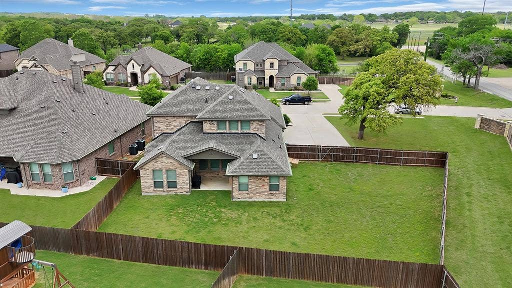 1905 Silver Falls Drive, Burleson, TX 76028 This room features light neutral-toned walls and carpeting, a ceiling fan with integrated lighting, and multiple windows allowing for natural light