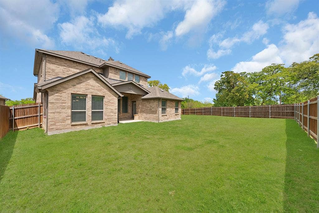 1905 Silver Falls Drive, Burleson, TX 76028 The property features an expansive, well-maintained lawn with a privacy fence