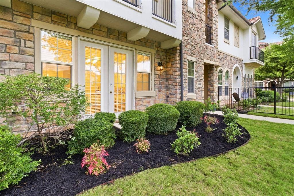 6748 San Roque, Irving, TX 75039 The property features an attractive stone facade with multiple windows and a set of white French doors
