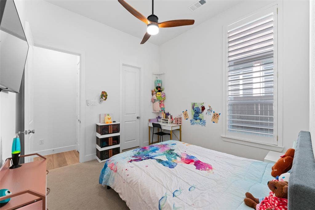216 Shetland Lane, Northlake, TX 76247 The room features a ceiling fan with light, a window with horizontal blinds, and light-colored carpeting