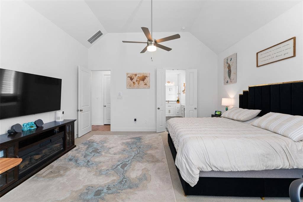 216 Shetland Lane, Northlake, TX 76247 This room features vaulted ceilings, a ceiling fan, and a light-colored rug with a distinct pattern