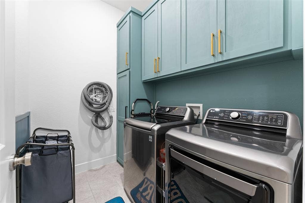 216 Shetland Lane, Northlake, TX 76247 This laundry area features sleek teal cabinetry with gold-toned hardware, providing ample storage