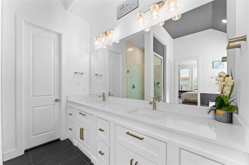 216 Shetland Lane, Northlake, TX 76247 The bathroom features a double vanity with white cabinetry, light-colored countertops, and gold-toned hardware