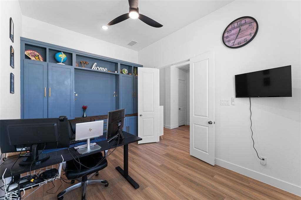 216 Shetland Lane, Northlake, TX 76247 This room features wood-look flooring, a ceiling fan, and a built-in blue storage unit with shelving