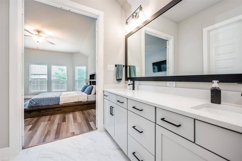 2801 Bedford Road, Northlake, TX 76226 Bathroom featuring a dual vanity with white cabinetry, matte black hardware, and a white countertop