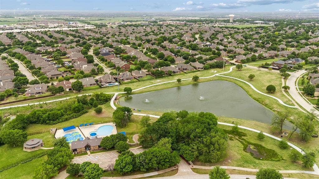 1221 Amistad Drive, Prosper, TX 75078 Aerial view of the neighborhood featuring residential properties, a community pool, a large pond with a fountain, and walking paths