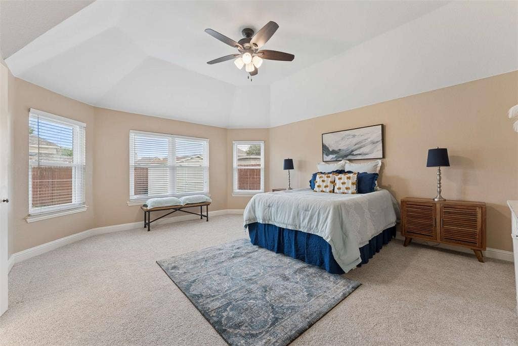 1221 Amistad Drive, Prosper, TX 75078 This room features a tray ceiling with a ceiling fan, carpeted flooring, and multiple windows with blinds