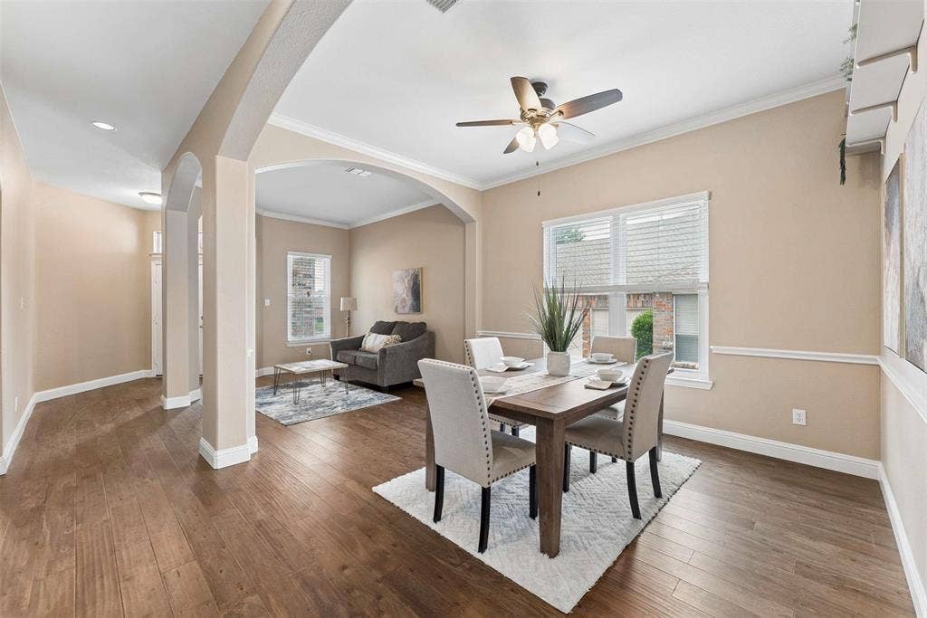 1221 Amistad Drive, Prosper, TX 75078 This open-concept living area features rich hardwood flooring and arched entryways
