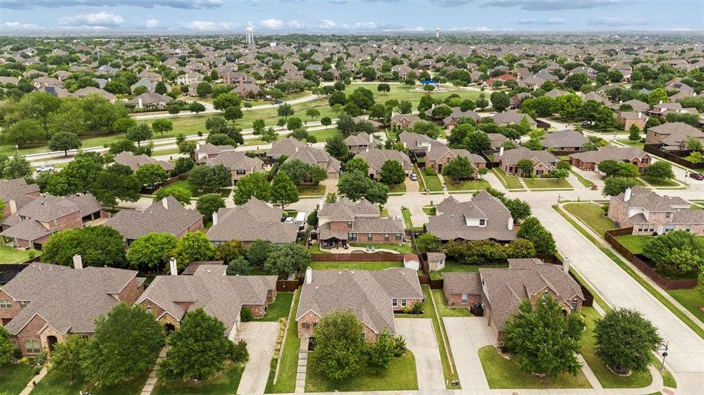 1221 Amistad Drive, Prosper, TX 75078 Aerial view of the neighborhood showcasing numerous properties with lush green landscaping and mature trees