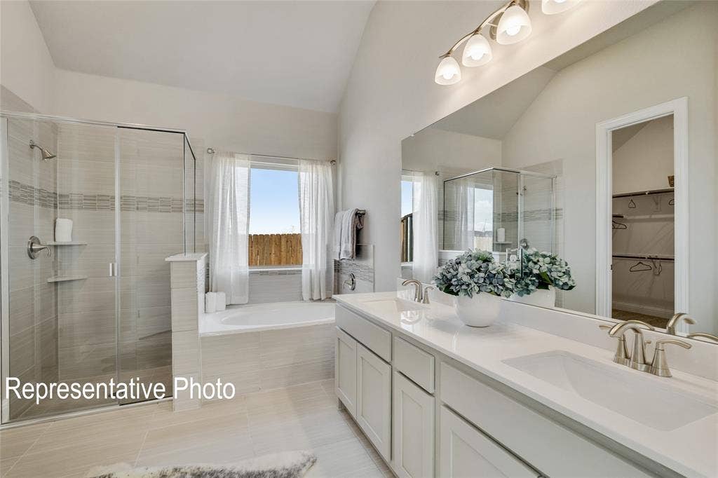 1415 Odette Drive, Arlington, TX 76013 The bathroom features a glass-enclosed shower, a separate bathtub beneath a window, and a double vanity with two sinks