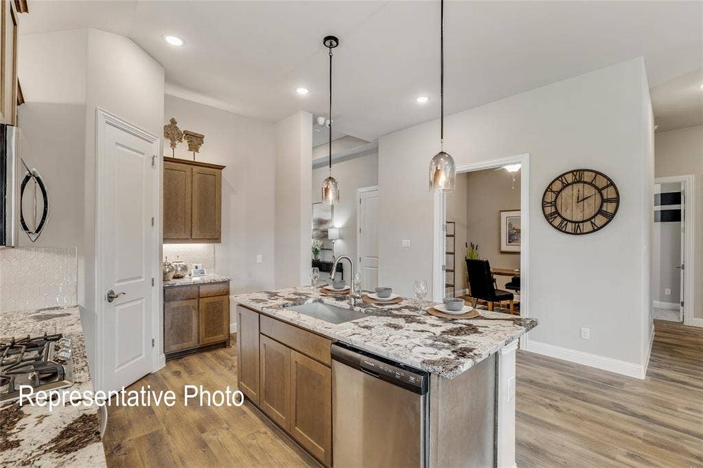 1415 Odette Drive, Arlington, TX 76013 The property features a kitchen with a large island, granite countertops, and stainless steel appliances