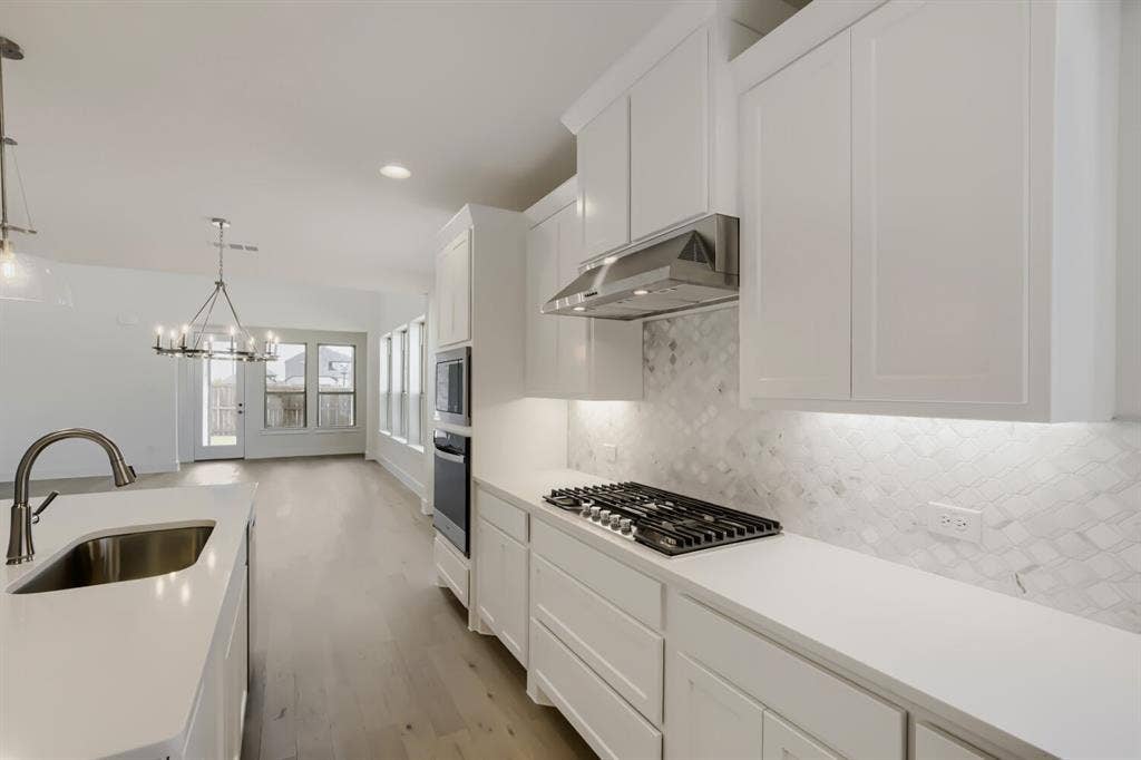 828 Stone Grove Road, Lavon, TX 75166 Kitchen featuring white shaker cabinetry, light-toned countertops, a stainless steel gas cooktop, built-in double ovens, and a patterned tile backsplash