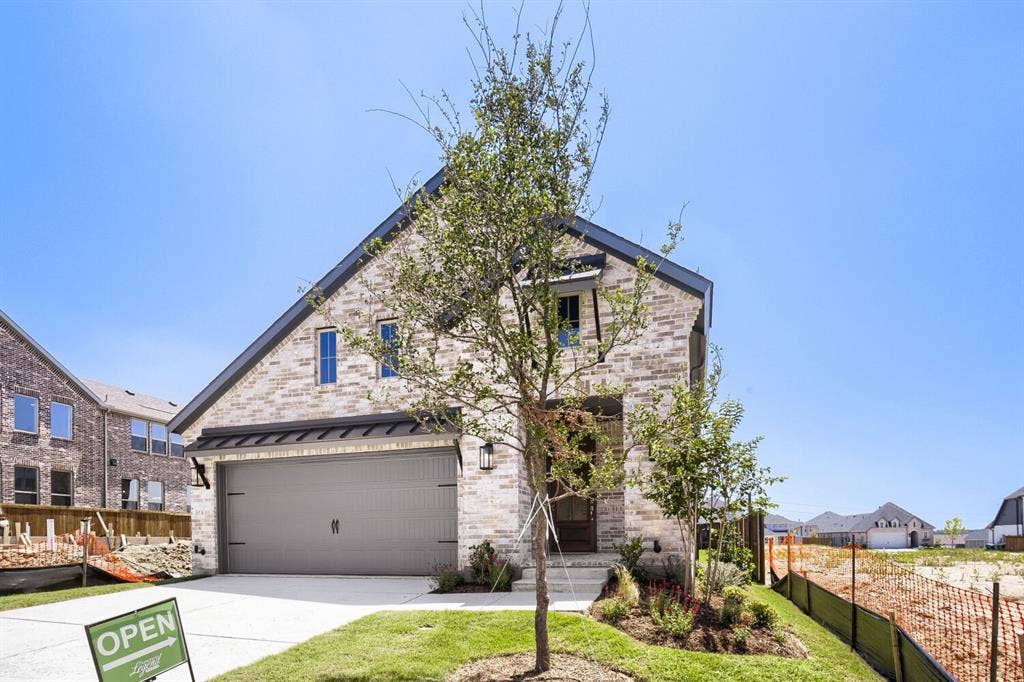 828 Stone Grove Road, Lavon, TX 75166 Contemporary brick facade with dark trim, featuring a prominent gable roofline and a two-car garage