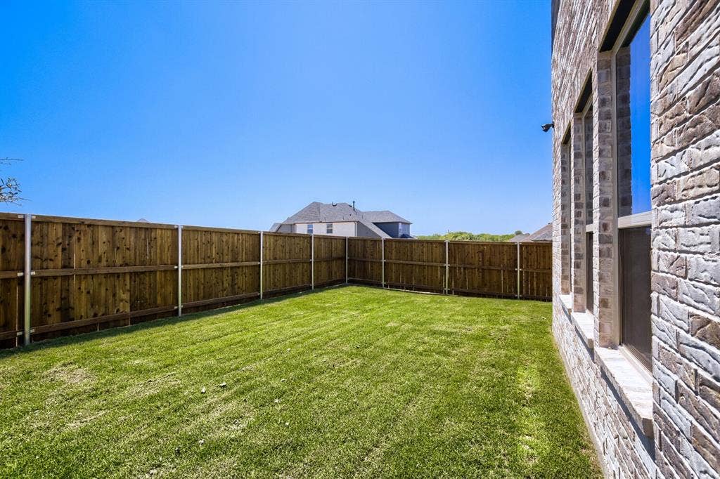 828 Stone Grove Road, Lavon, TX 75166 Expansive backyard featuring a lush lawn and a newly installed wood privacy fence