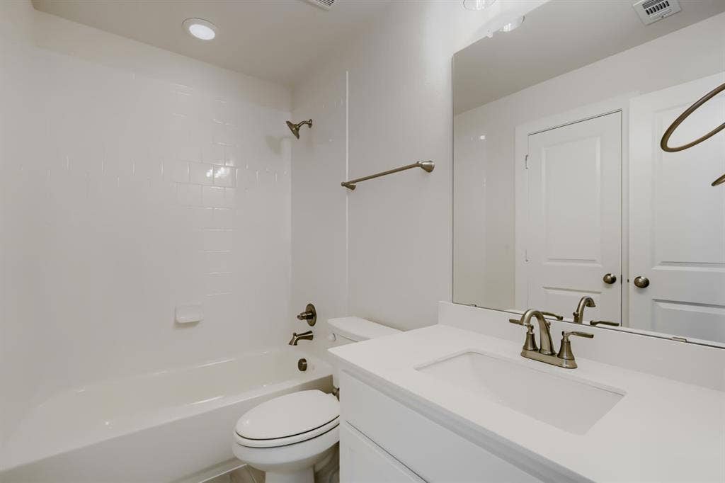 828 Stone Grove Road, Lavon, TX 75166 Bathroom featuring a vanity with an integrated sink, brushed nickel faucet, and a large mirror