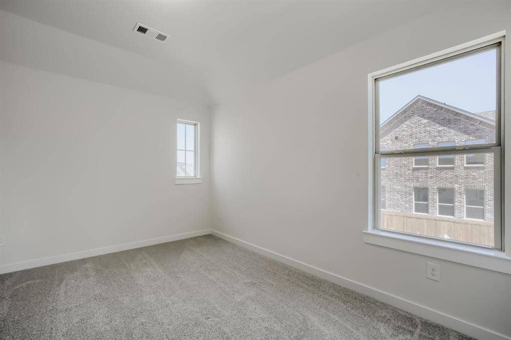 828 Stone Grove Road, Lavon, TX 75166 Light-filled room featuring neutral wall tones, gray carpeting, a large double-hung window, a smaller vertical window, and white trim throughout