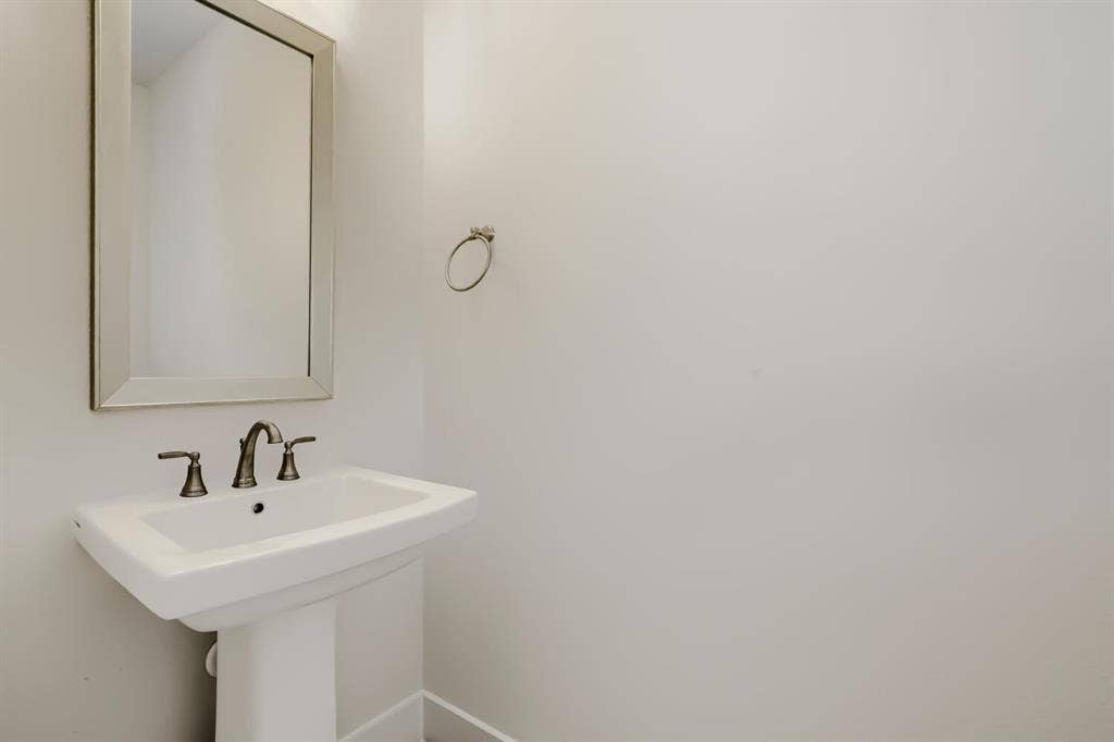828 Stone Grove Road, Lavon, TX 75166 Pedestal sink with a wide basin, bronze-finish faucet, and coordinating towel ring