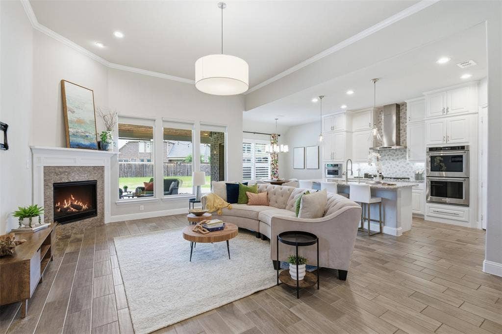 11414 Alejandra Lane, Frisco, TX 75035 Open-concept living area with wood-finish flooring and a contemporary fireplace