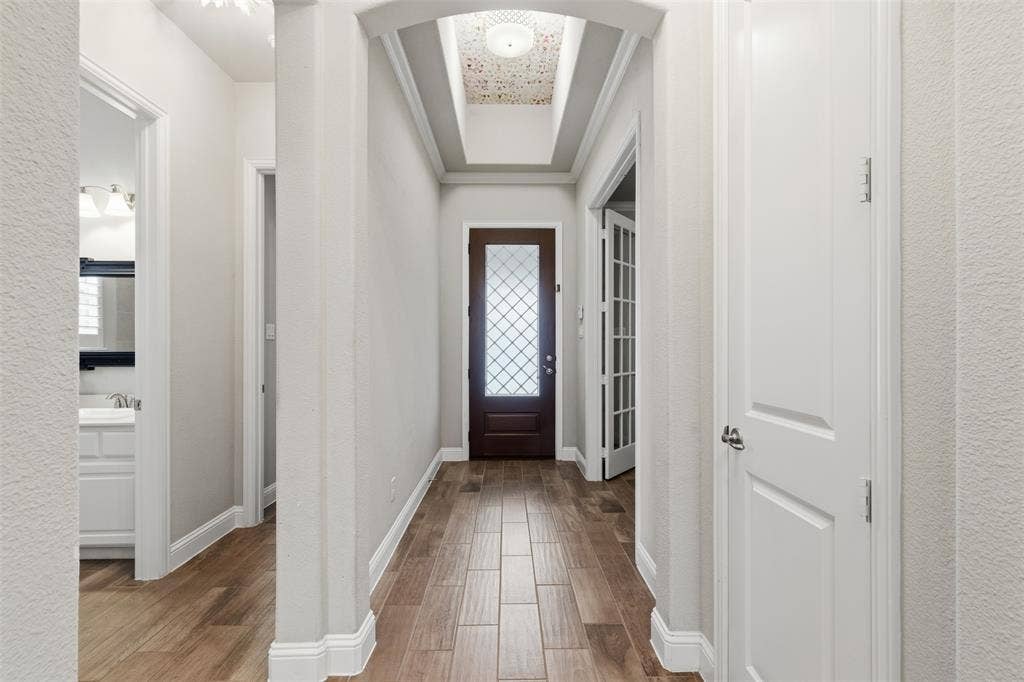 11414 Alejandra Lane, Frisco, TX 75035 Foyer featuring wood-finish tile flooring, an arched entryway, and a dark wood front door with decorative glass