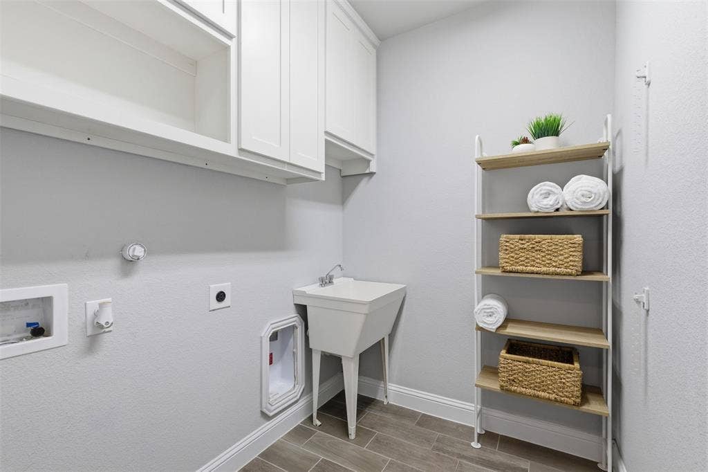 11414 Alejandra Lane, Frisco, TX 75035 Utility room featuring wood-finish tile flooring, a built-in utility sink, and white shaker-style cabinetry with upper storage