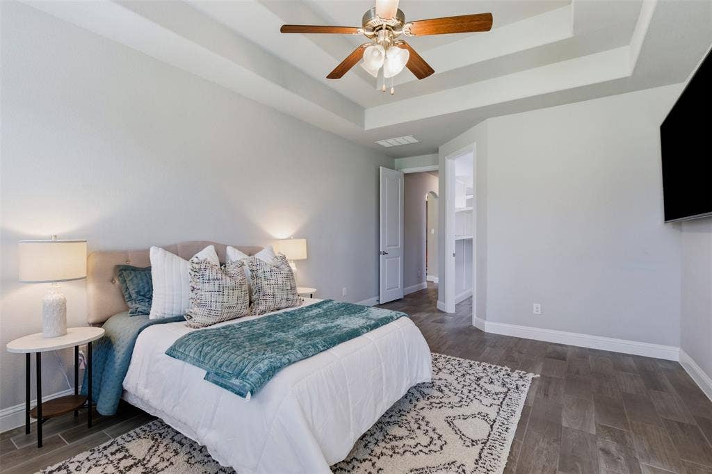 11414 Alejandra Lane, Frisco, TX 75035 Recessed tray ceiling with a ceiling fan, wood-finish flooring, and white baseboards
