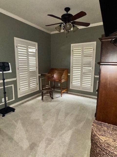 Sitting room featuring crown molding, a ceiling fan, and carpet flooring