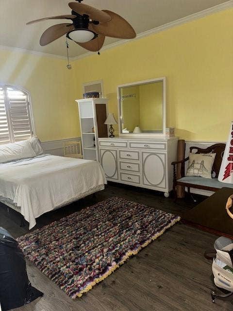 Bedroom with crown molding, ceiling fan, and wood finished floors