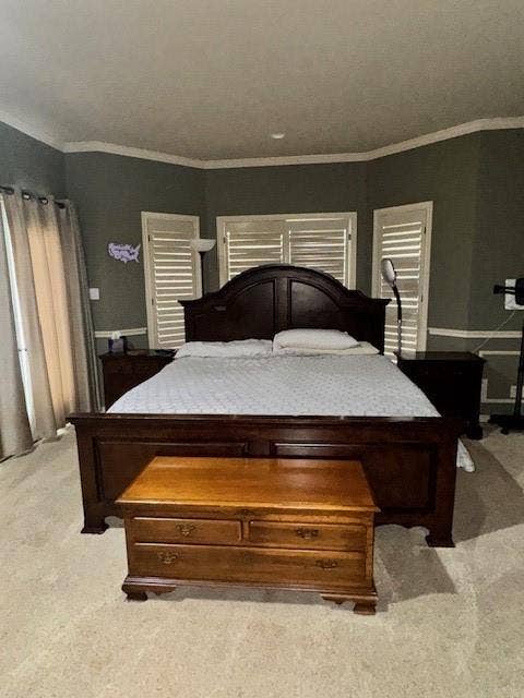Carpeted bedroom featuring ornamental molding