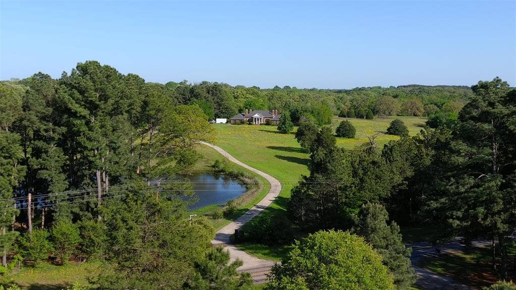 Birds eye view of property featuring a wooded view and a water view