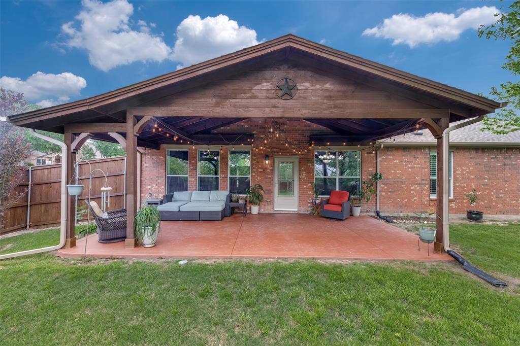 Covered stained concrete patio provides a panoramic view of the huge yard and lake beyond.