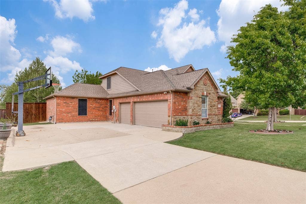 An additional parking pad, plus a small one for trash containers, at the side-entry garage is complemented by built-in basketball hoop. 3-car garage has sealed floors and 30' of 5' deep heavy duty shelving for storage.