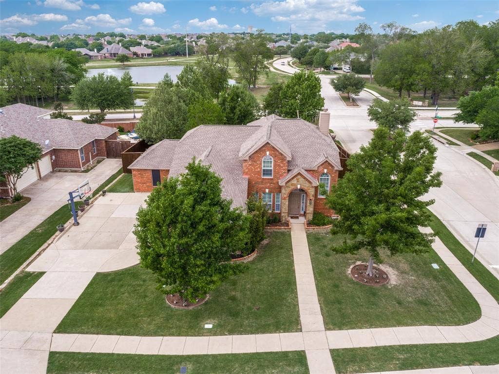 Stone archway and waterline, keystone accents, carriage light, and established trees make for great curb appeal!