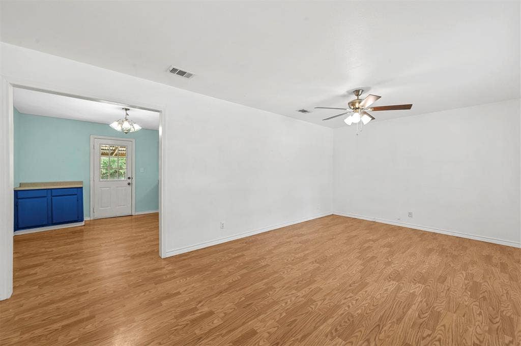 214 Wildflower Drive, Gun Barrel City, TX 75156 Unfurnished room with ceiling fan with notable chandelier and light hardwood / wood-style floors