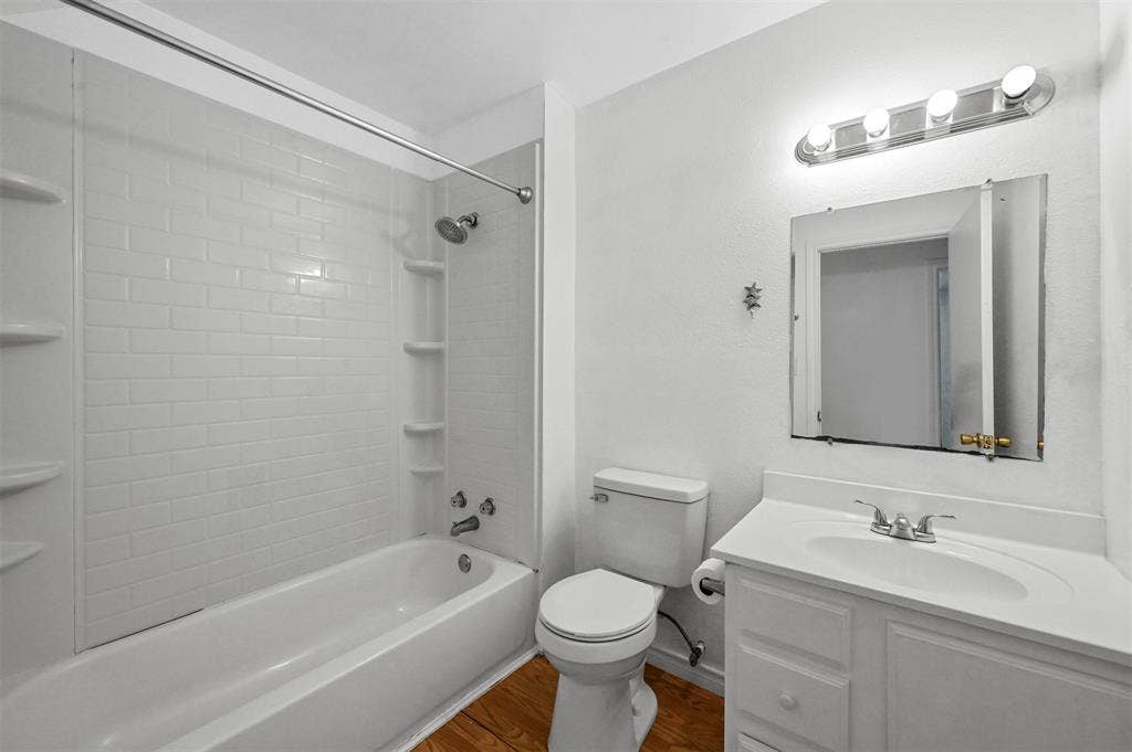 214 Wildflower Drive, Gun Barrel City, TX 75156 Full bathroom with vanity, toilet, hardwood / wood-style floors, and tiled shower / bath