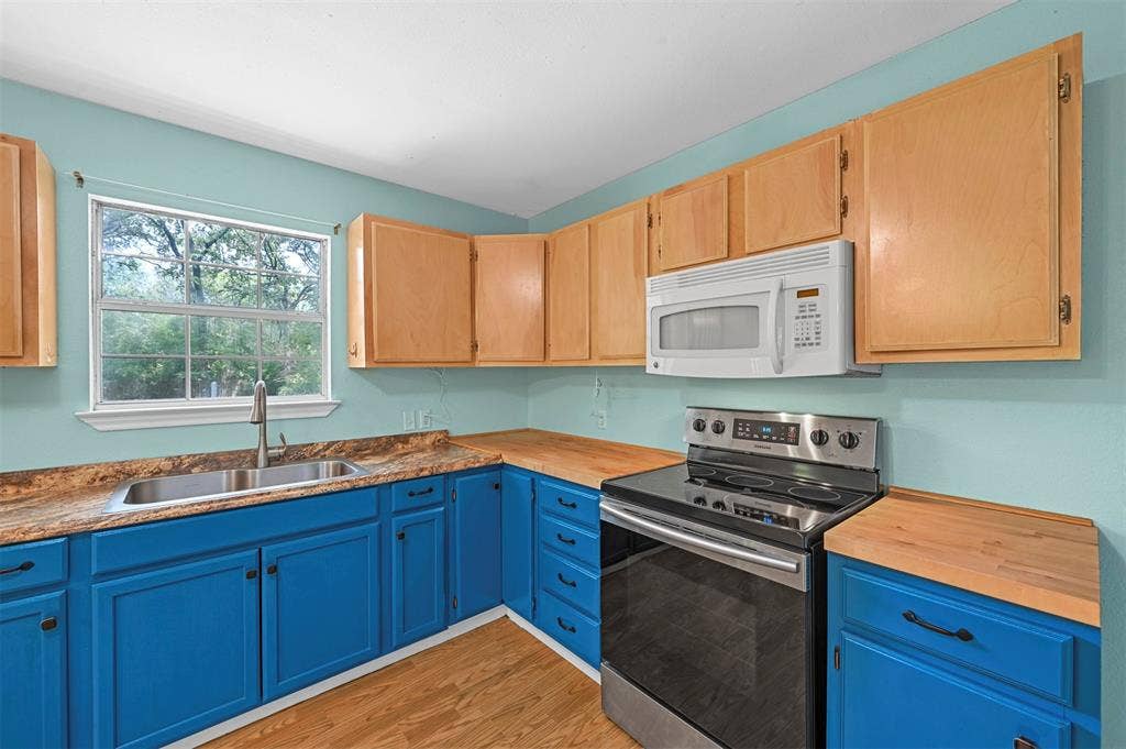 214 Wildflower Drive, Gun Barrel City, TX 75156 Kitchen featuring electric range, sink, light hardwood / wood-style floors, and wooden counters