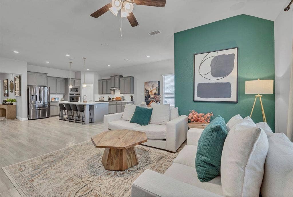 1000 Westwood Lane, Argyle, TX 76226 This inviting living space features light-colored flooring and an area rug, complemented by a ceiling fan