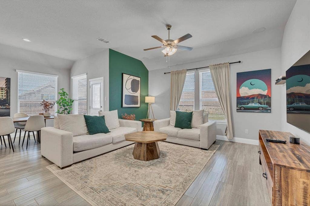 1000 Westwood Lane, Argyle, TX 76226 The living area features light-toned flooring, a ceiling fan, and large windows with blinds