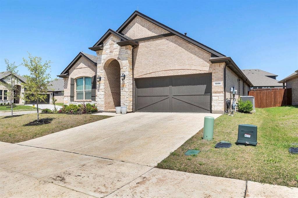 1000 Westwood Lane, Argyle, TX 76226 The property features a brick and stone exterior with an arched entryway