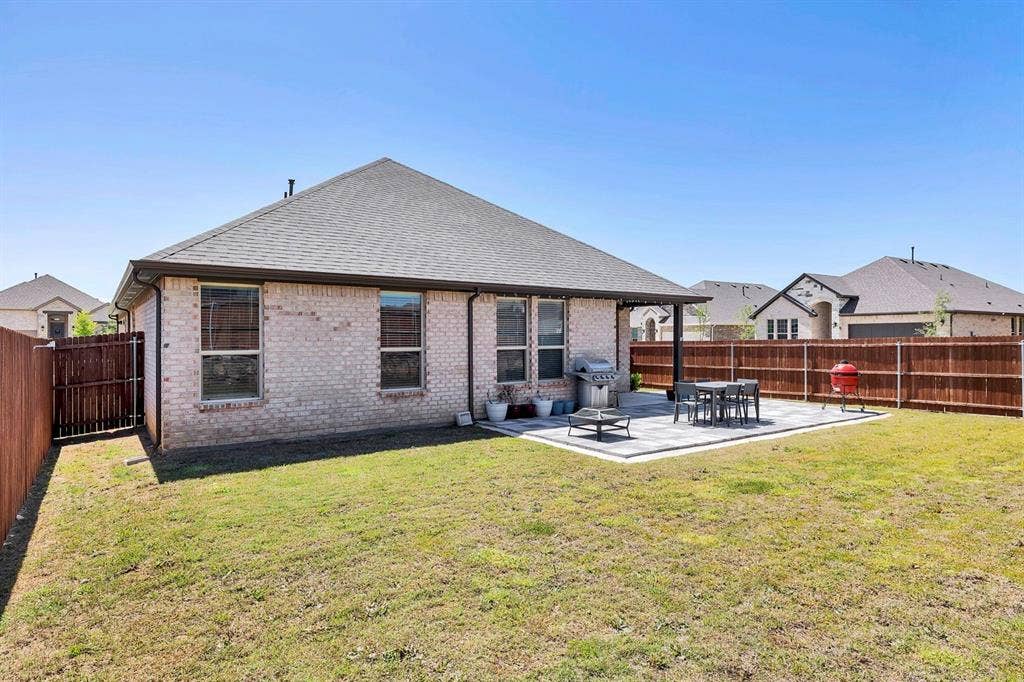 1000 Westwood Lane, Argyle, TX 76226 The property features a spacious backyard with a well-maintained lawn and a private wooden fence