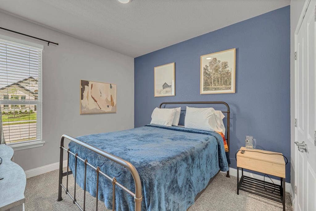 1000 Westwood Lane, Argyle, TX 76226 This room features a window with horizontal blinds, carpeted flooring, and a bed with a metal frame