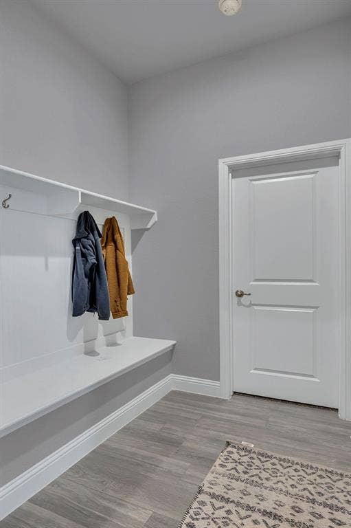 1000 Westwood Lane, Argyle, TX 76226 Entryway featuring wood-look flooring, a white built-in bench with coat hooks, and a white door with a brass-toned knob