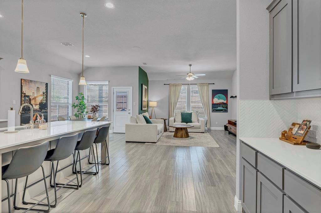 1000 Westwood Lane, Argyle, TX 76226 The property features an open living area with light-colored flooring, recessed lighting, and a ceiling fan