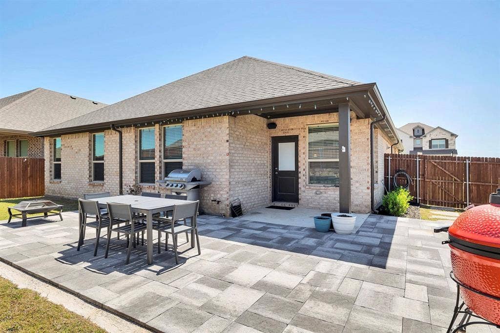 1000 Westwood Lane, Argyle, TX 76226 The property features a brick exterior with a covered patio area