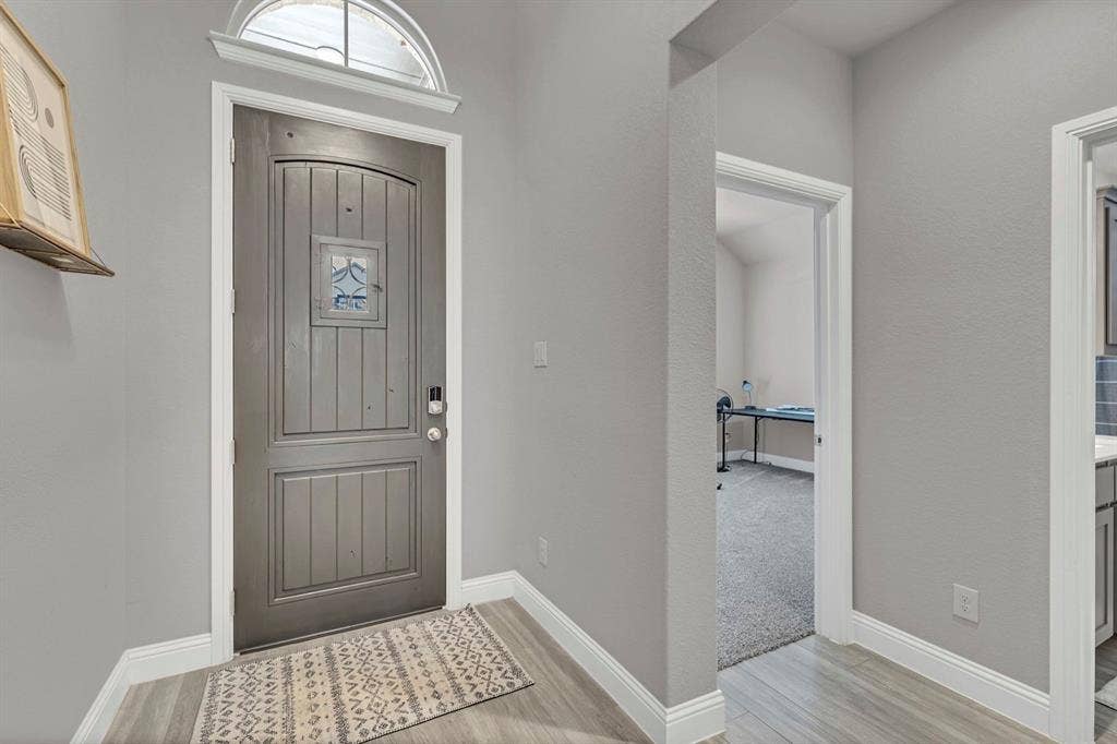 1000 Westwood Lane, Argyle, TX 76226 Entryway featuring a paneled door with decorative glass, a transom window, and light gray walls