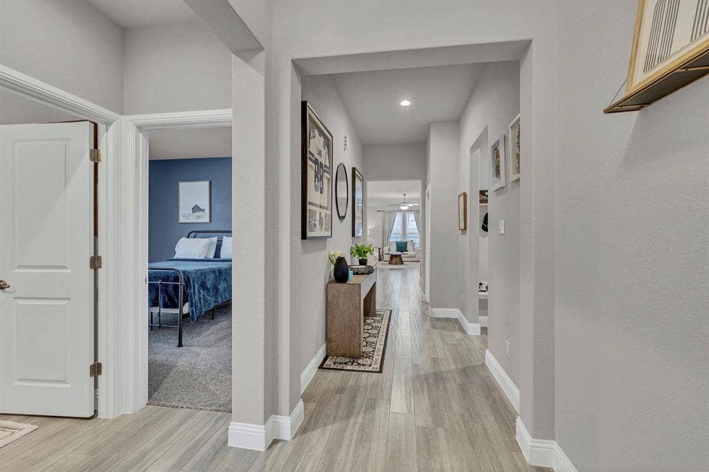 1000 Westwood Lane, Argyle, TX 76226 Hallway featuring light-toned flooring and neutral walls, with a view into a carpeted room with a blue accent wall